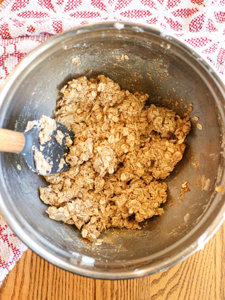 Stirring crust and topping ingredients in a mixing bowl on a table.