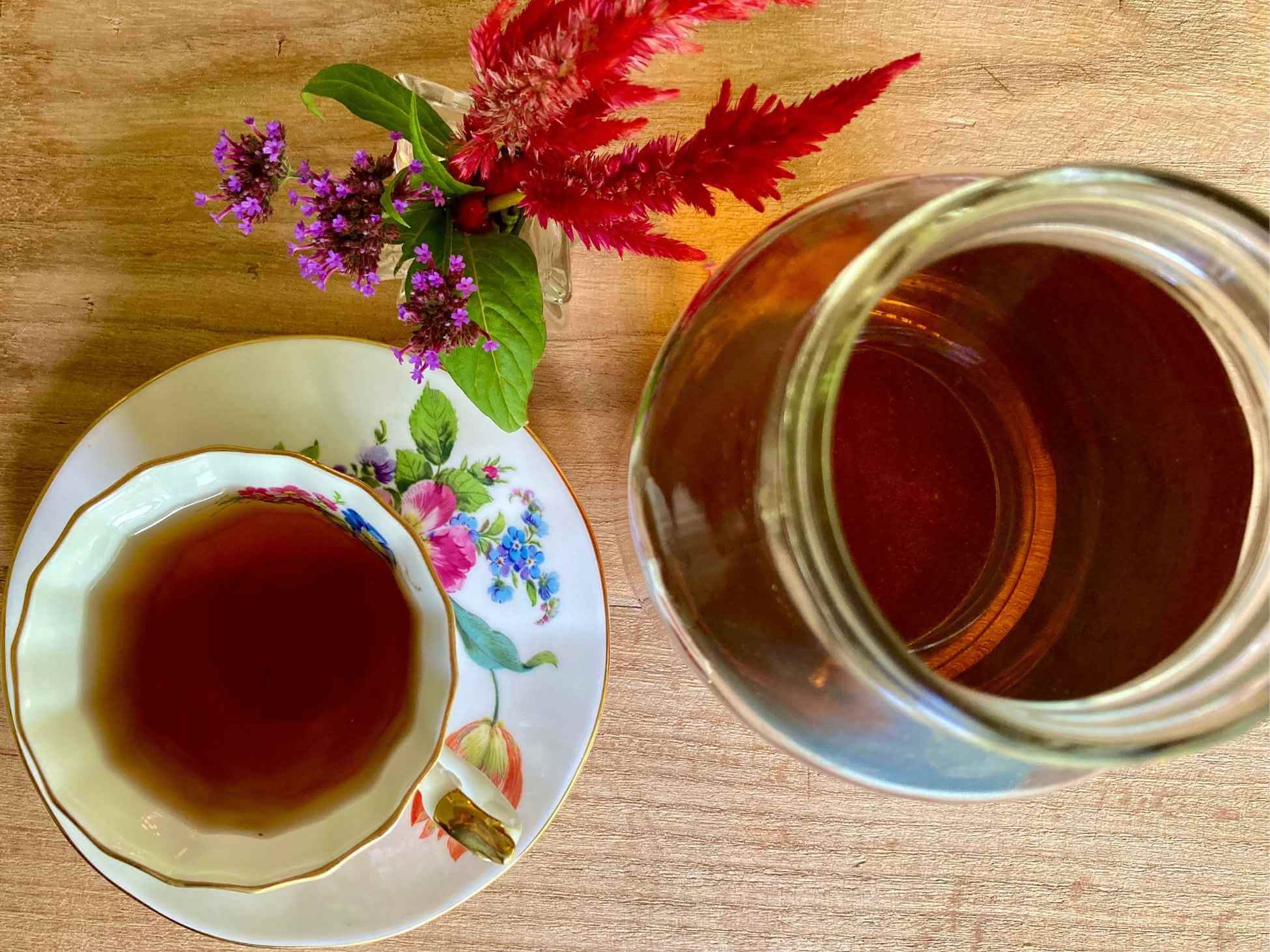 NORA tea in a floral teacup and a mason jar.