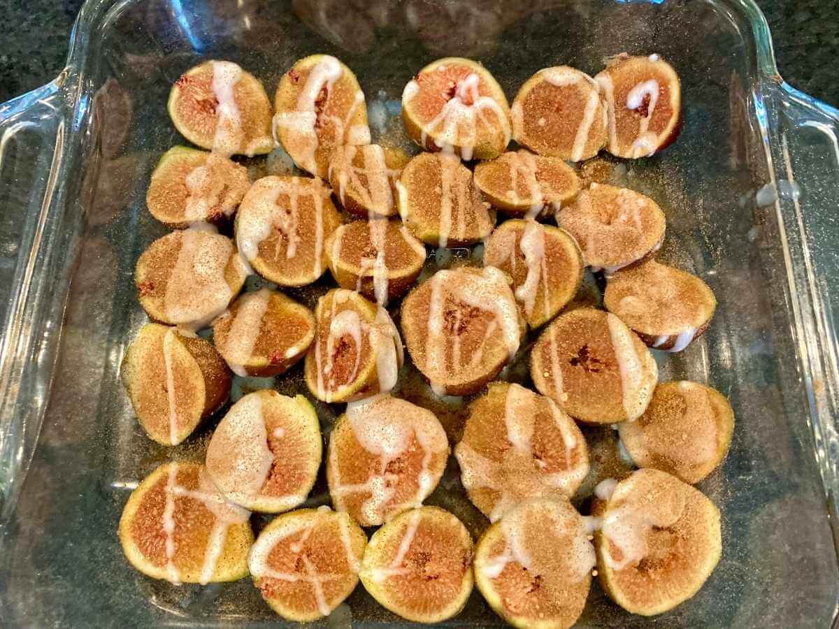 Drizzling coconut oil over fig halves.