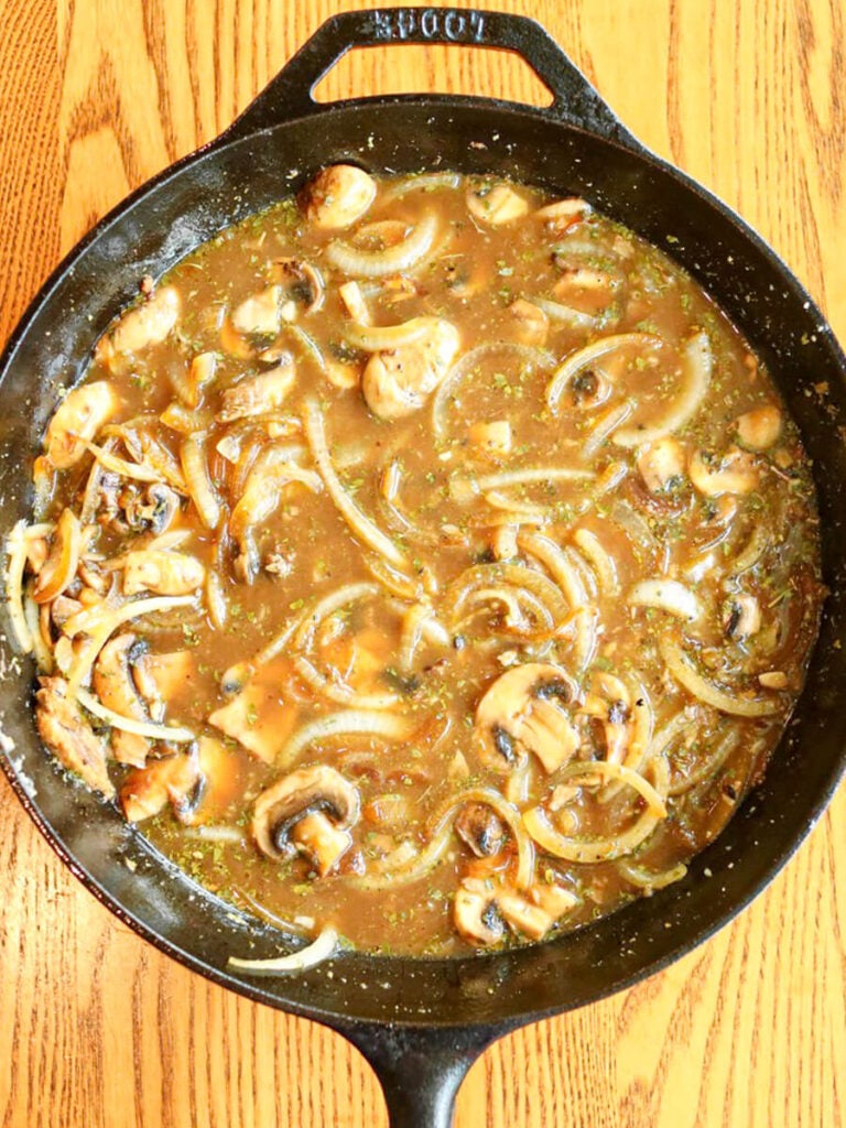 Mushroom and onion gravy in a cast iron skillet.