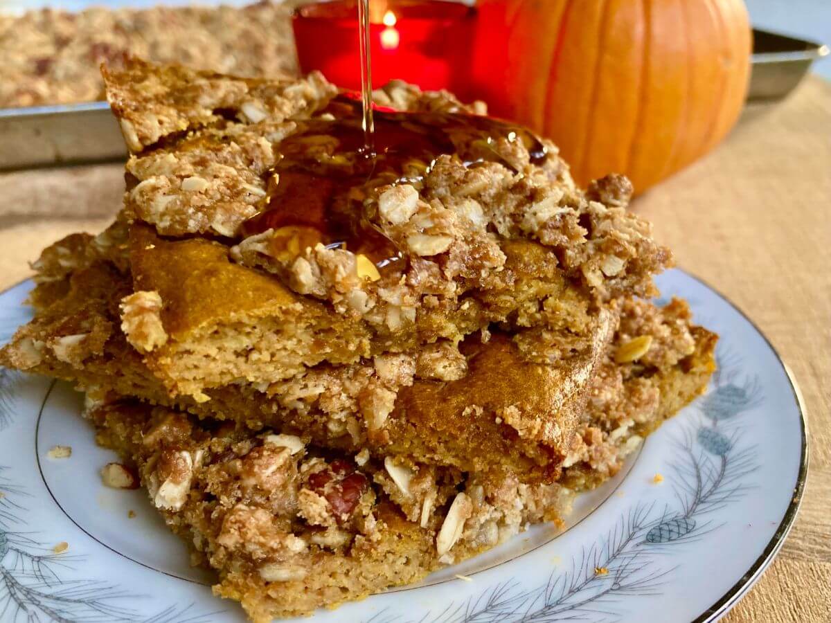 3 stacked slices of Pumpkin Crisp Sheet-Pan Pancakes with syrup