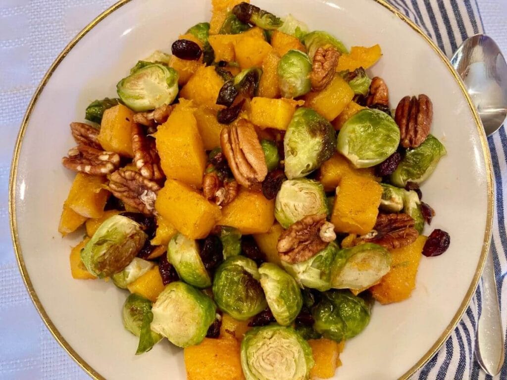 serving bowl and spoon with roasted Brussels sprouts and butternut squash