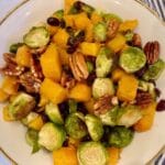 serving bowl and spoon with roasted Brussels sprouts and butternut squash