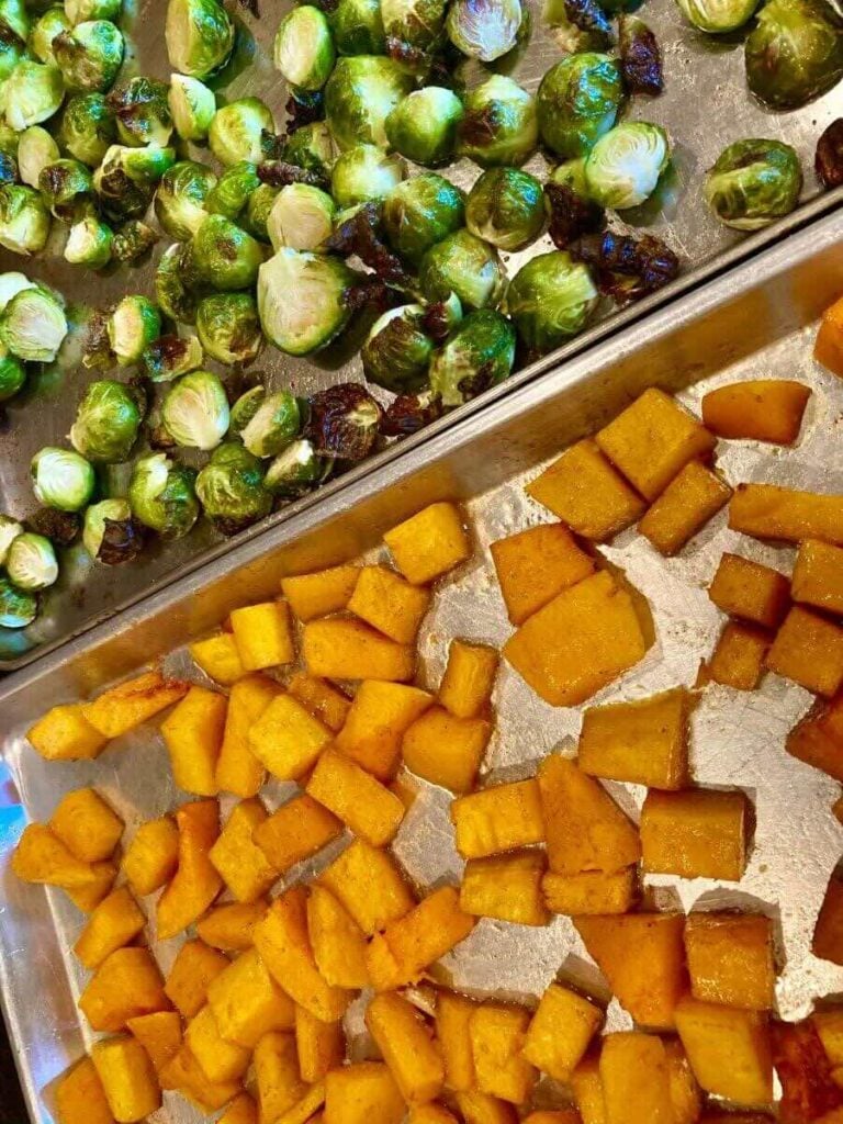 2 sheet pans with roasted butternut squash and Brussels sprouts.