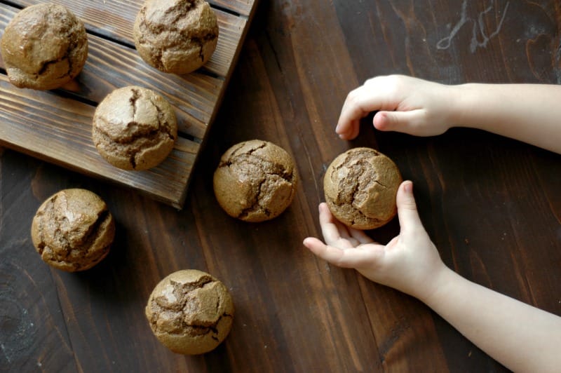 Child's hands reaching for gingerbread muffins