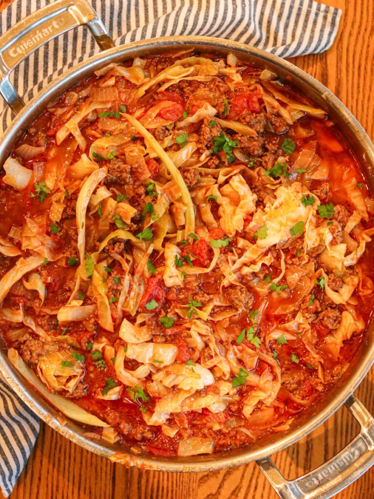 Cabbage bowls in a saute pan on a wooden table.