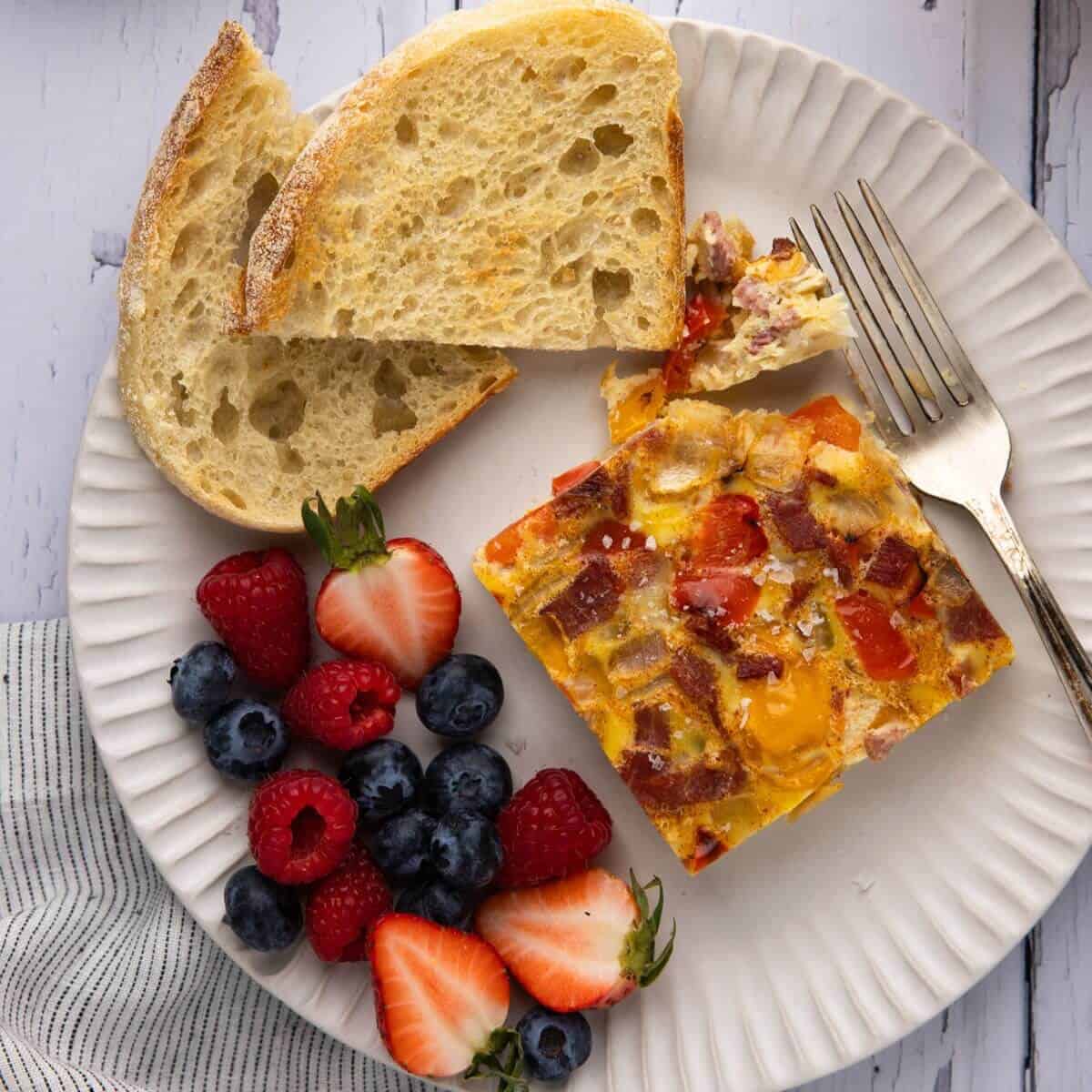 Dairy free egg bake on a plate with toast and fruit
