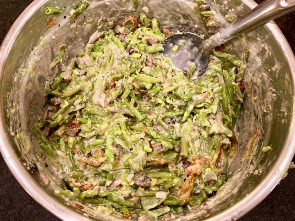Stirring green bean mixture in bowl