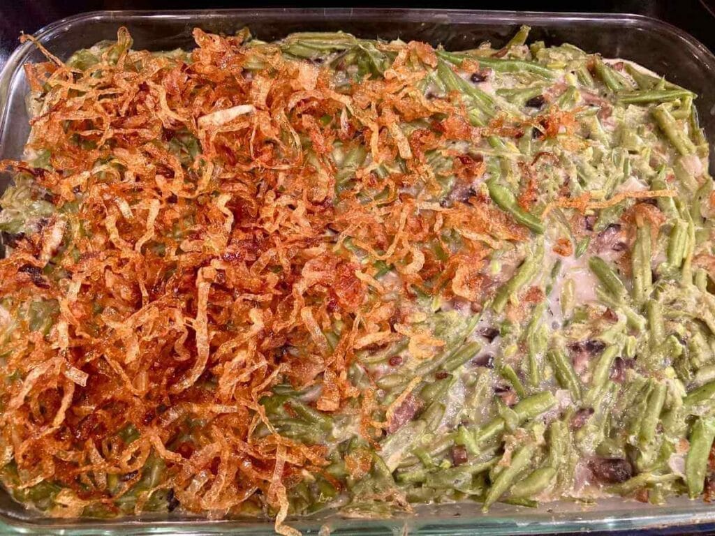 Sprinkling fried onions over green bean casserole