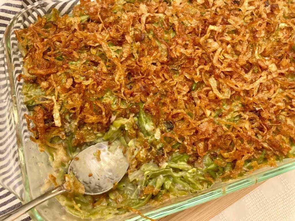 Spoon scooping green bean casserole out of dish