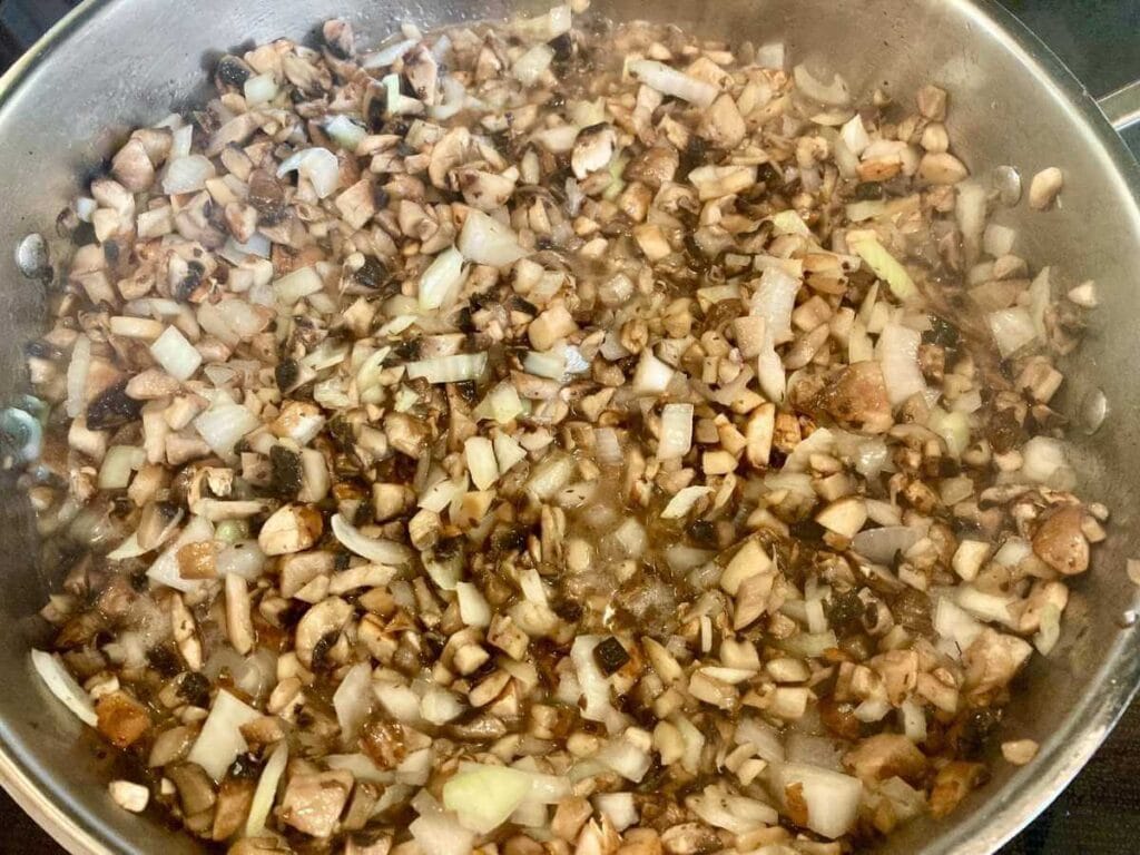 Sautéing mushrooms and onions in skillet