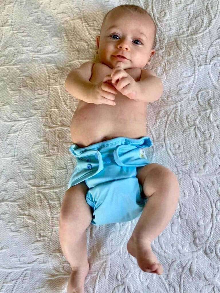 Baby wearing a blue cloth diaper