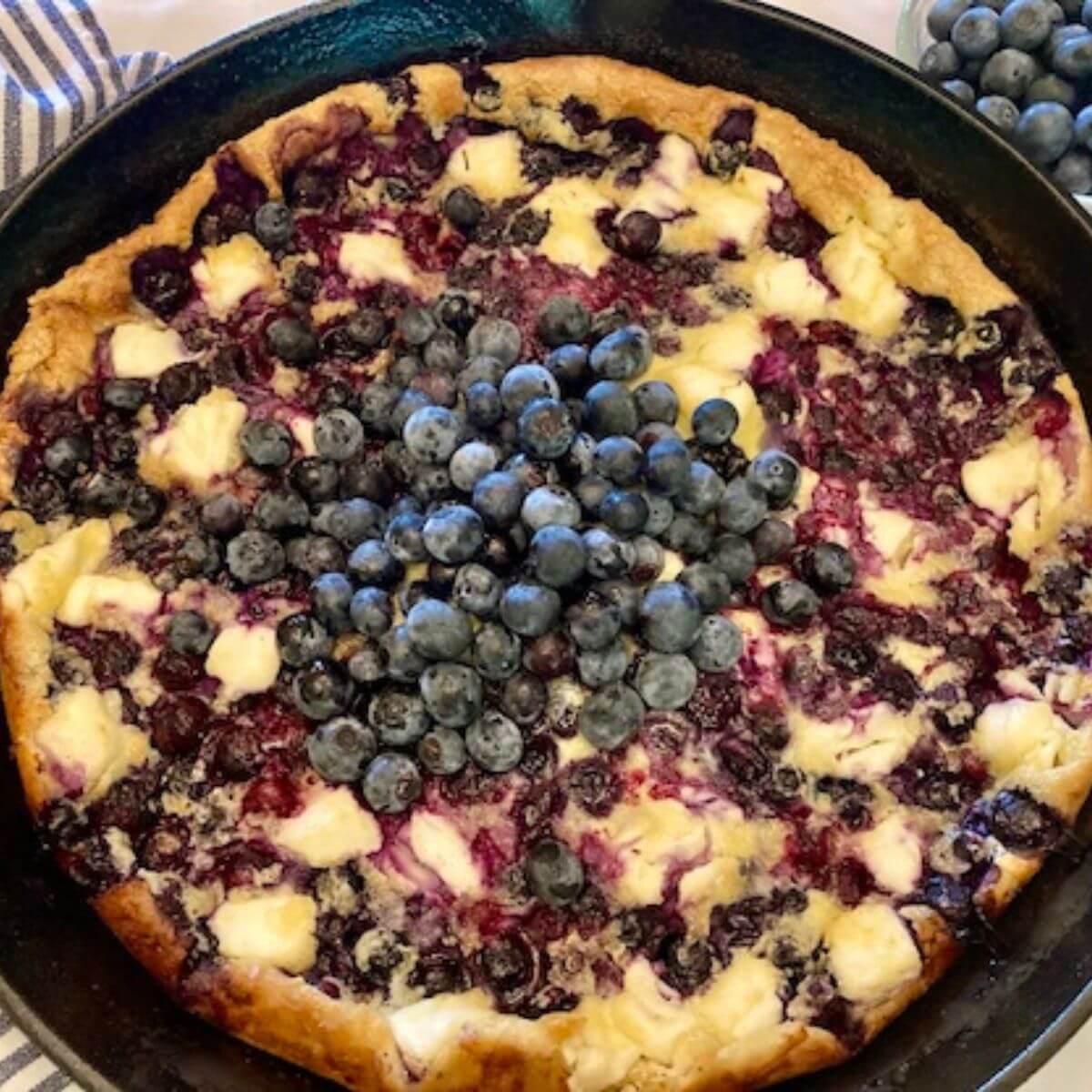 Blueberry cheesecake dutch baby in cast iron skillet