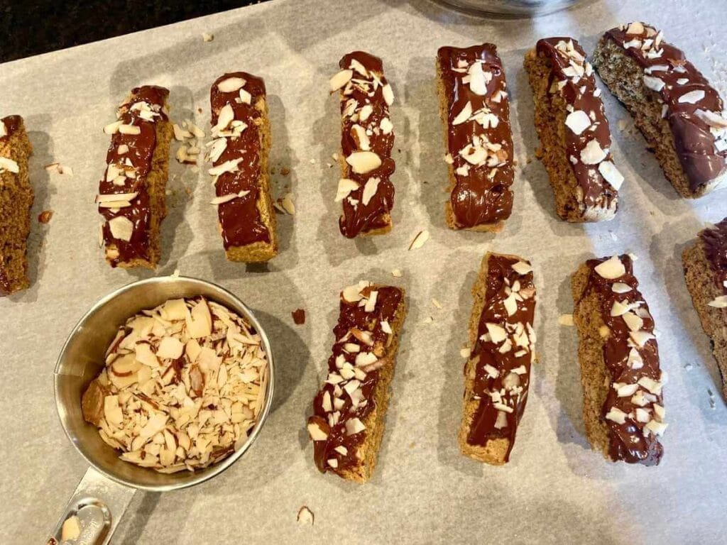 Sprinkling almonds on gluten-free biscotti