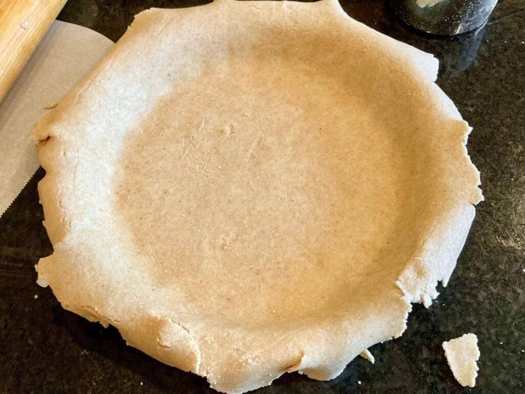 Close up of unbaked oat flour pie crust in pie crust