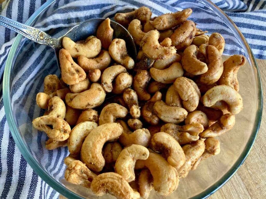 Scooping roasted cashews out of bowl