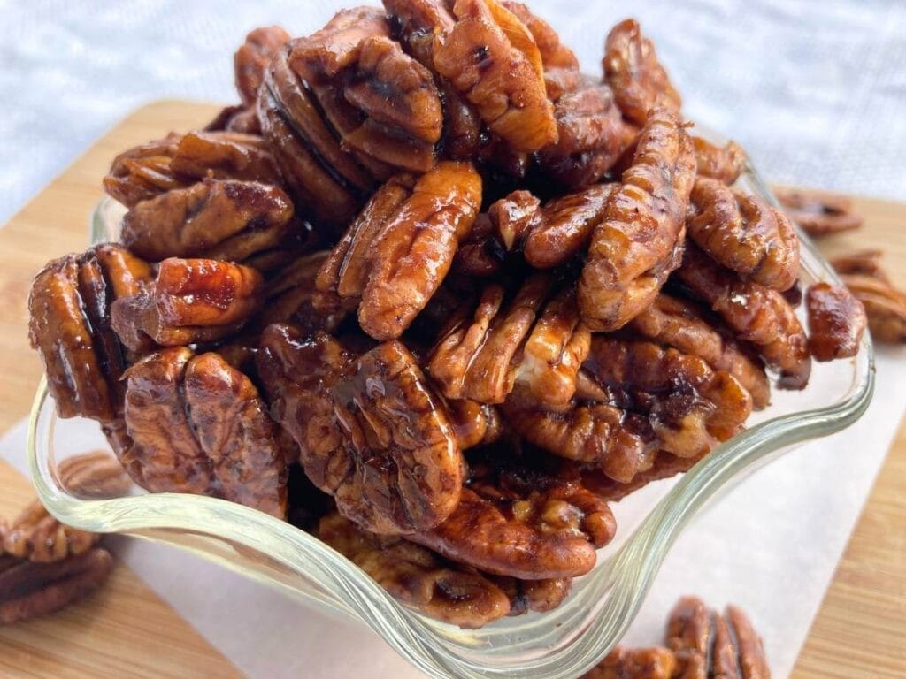 side view of candied pecans in glass dish
