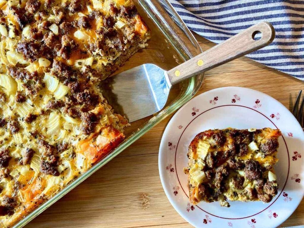 Piece of healthy egg strata on a plate and in a casserole dish