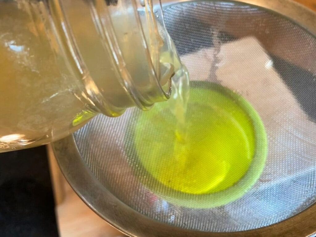 Pouring water kefir into glass bottle
