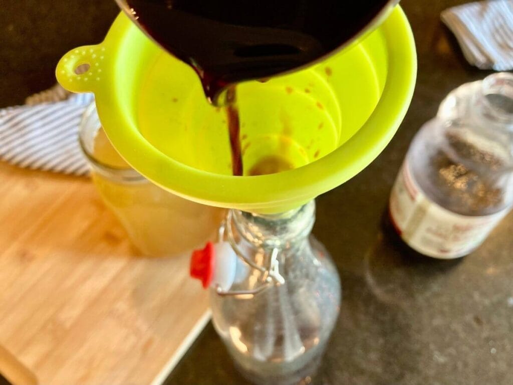 Pouring juice into glass bottle
