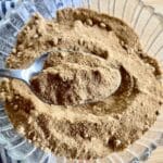 Spoon scooping powdered coconut sugar out of bowl