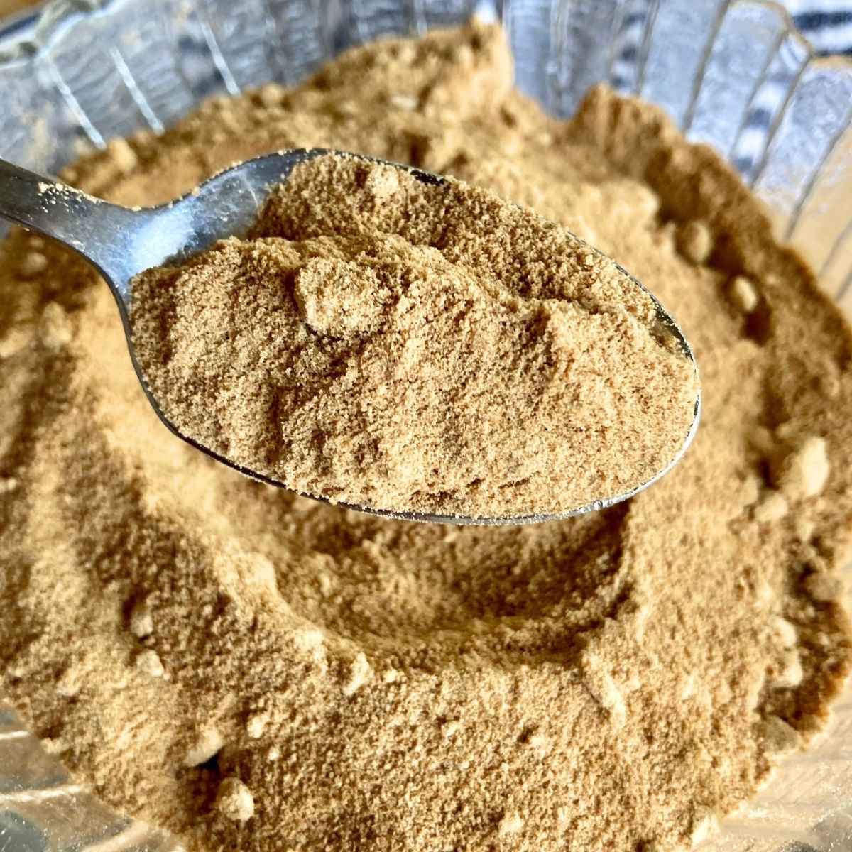 close up of spoon scooping powdered coconut sugar out of bowl