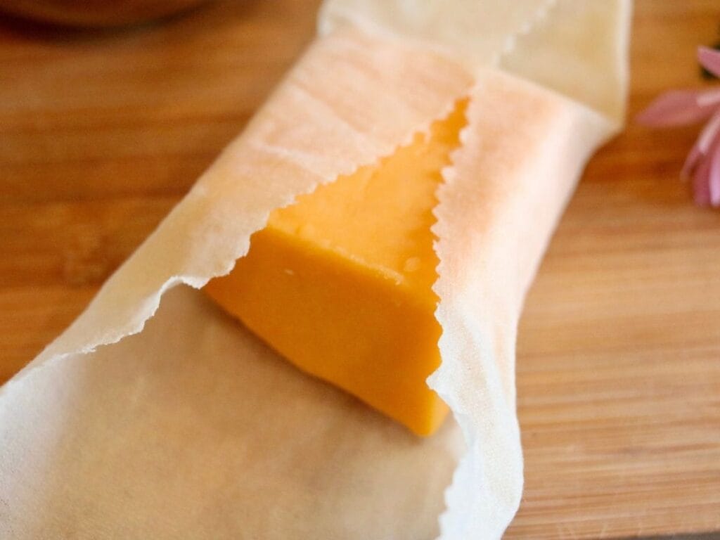 Cheese block partially wrapped in beeswax food wrap.