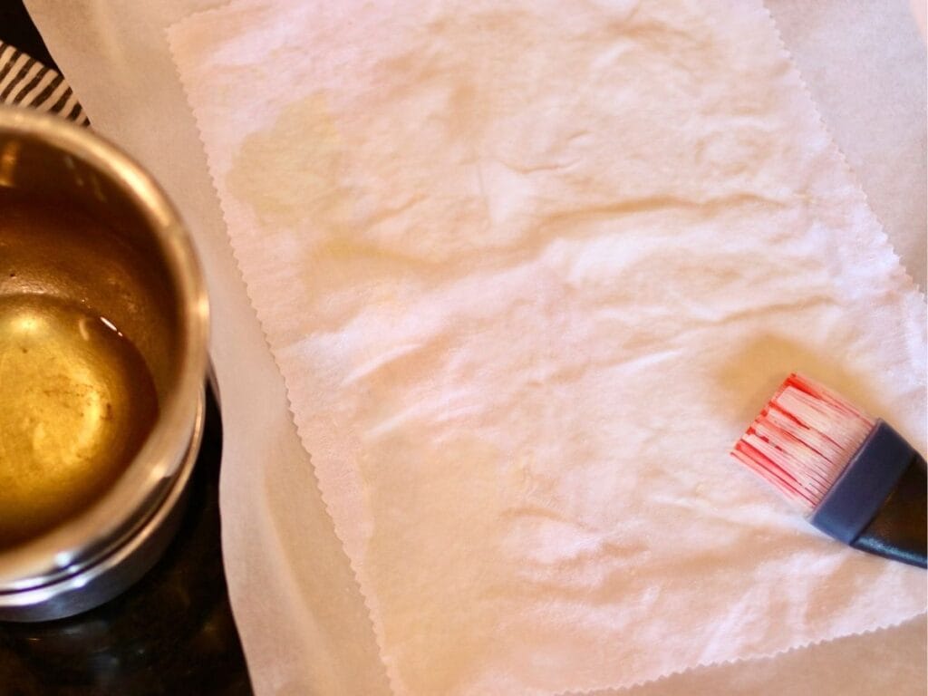 Spreading beeswax mixture on a piece of fabric with a silicone brush.