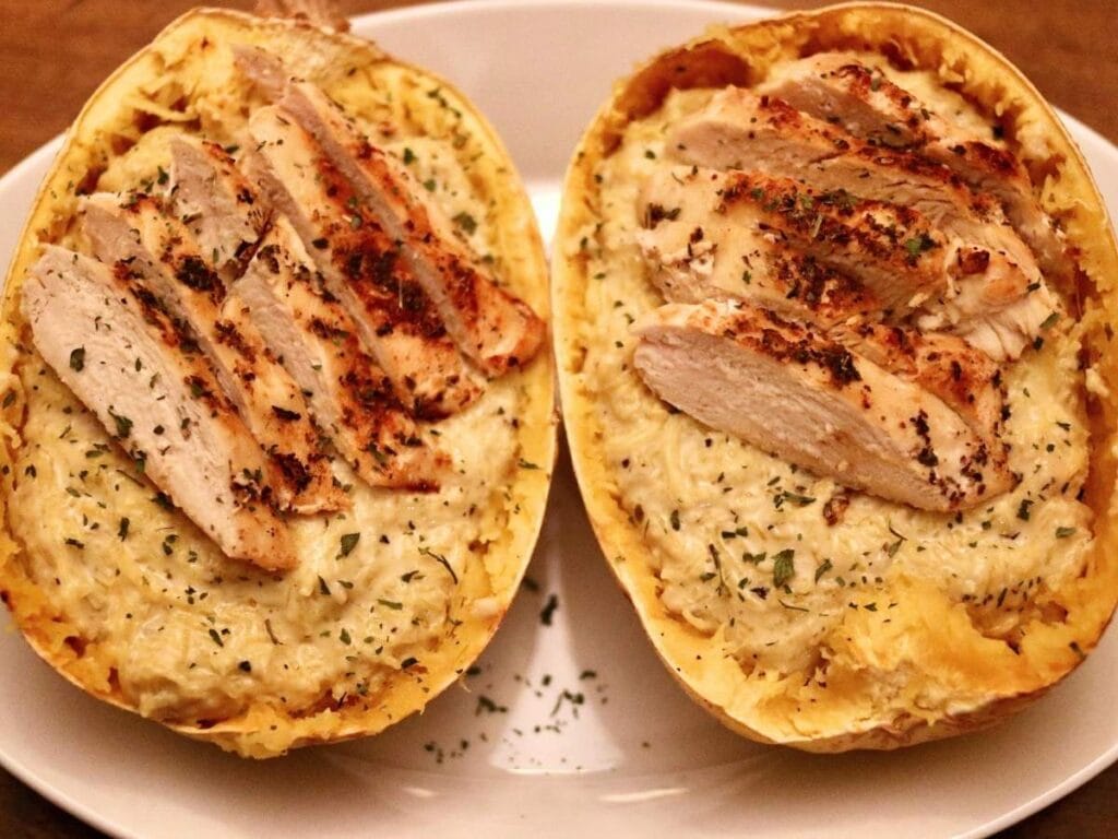 2 squash shells with chicken Alfredo spaghetti squash inside on a tray