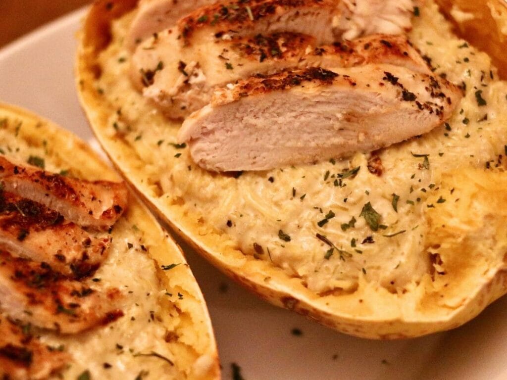 Closeup of chicken Alfredo spaghetti squash inside a squash shell