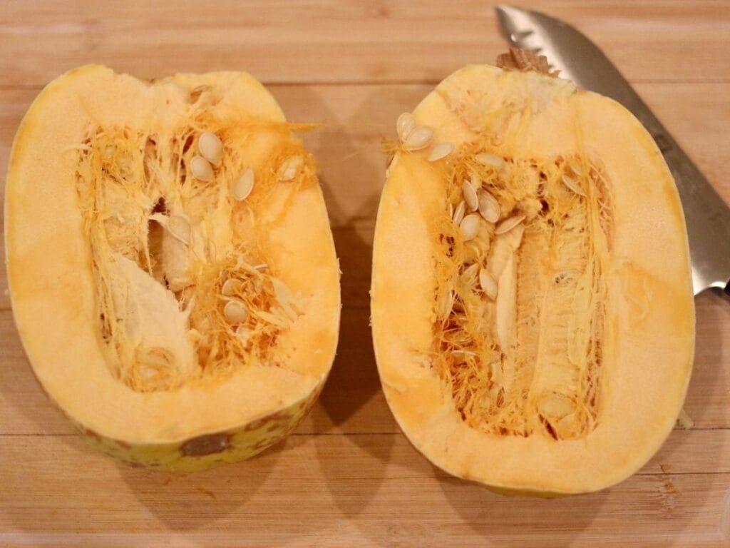 Spaghetti squash cut in half on a cutting board