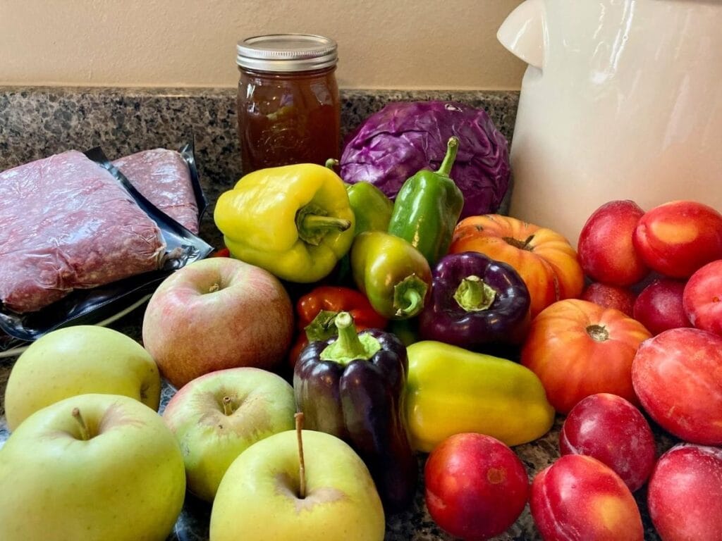 Fresh fruit, vegetables, meat, and honey on a counter