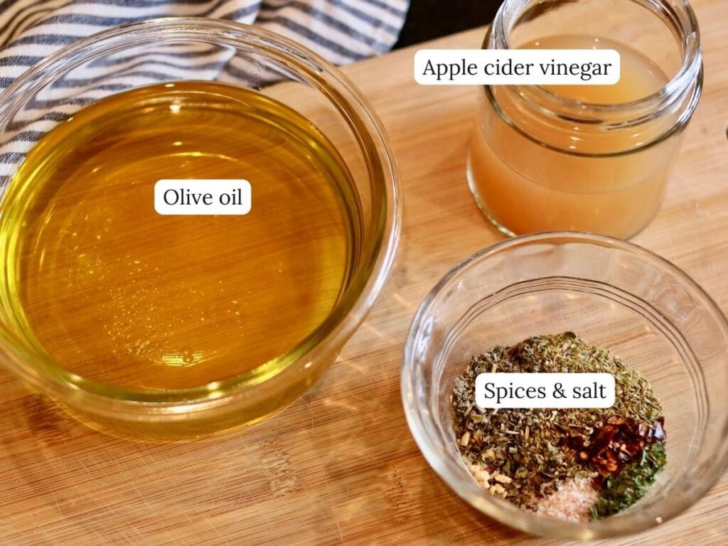 Ingredients for Italian vinaigrette on a wood cutting board