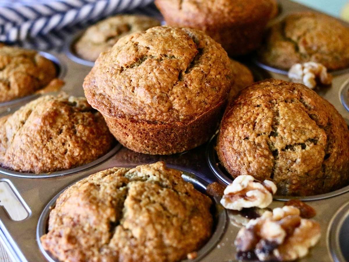 Oat flour banana muffins on and in a muffin pan..