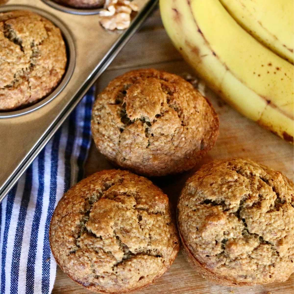 3 oat flour banana muffins beside muffin pan.