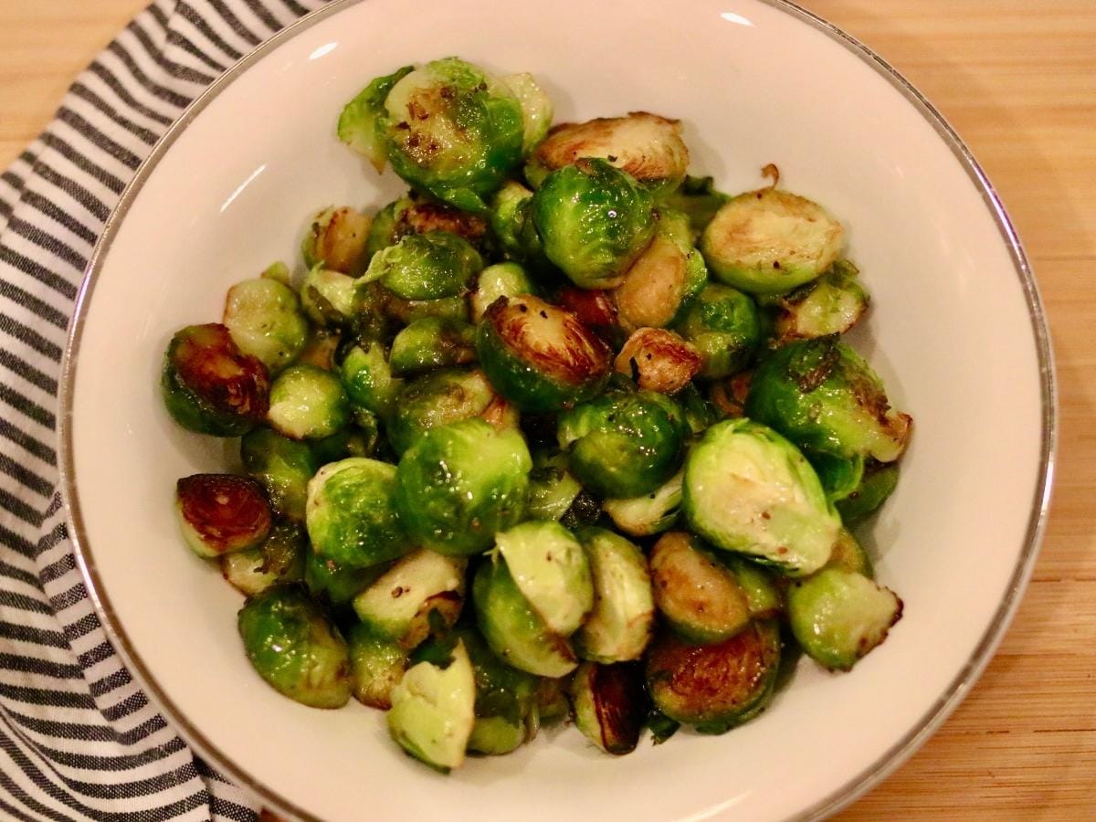 Stovetop Brussels sprouts in a bowl with a cloth napkin
