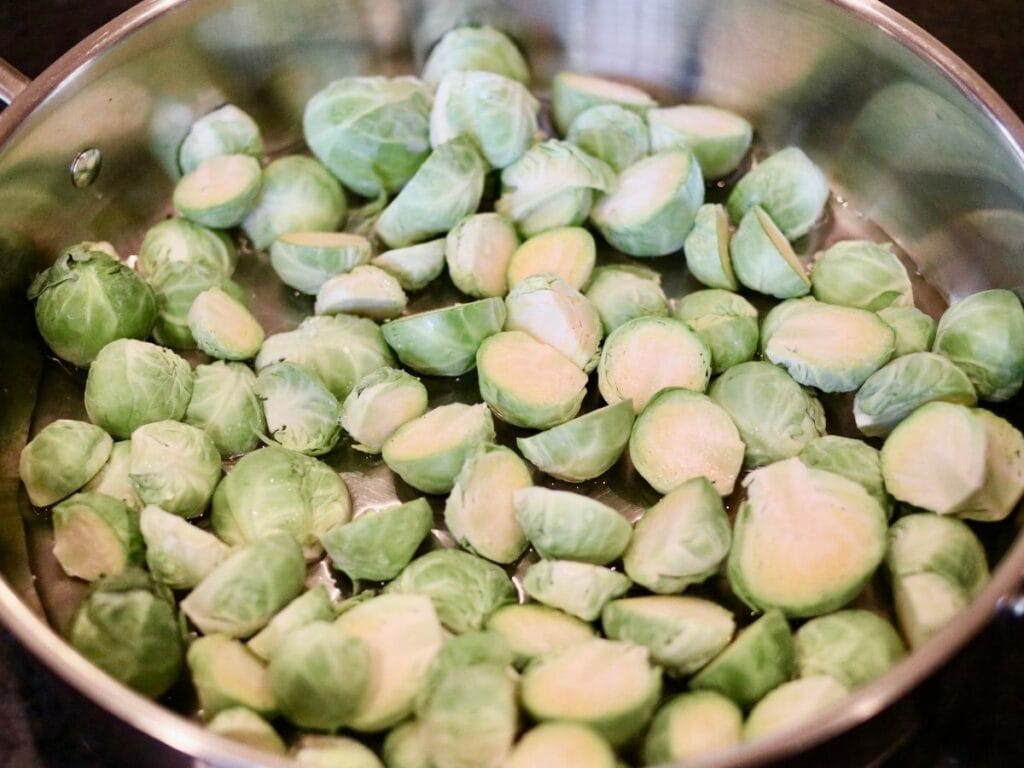 Brussels sprouts and water in a skillet