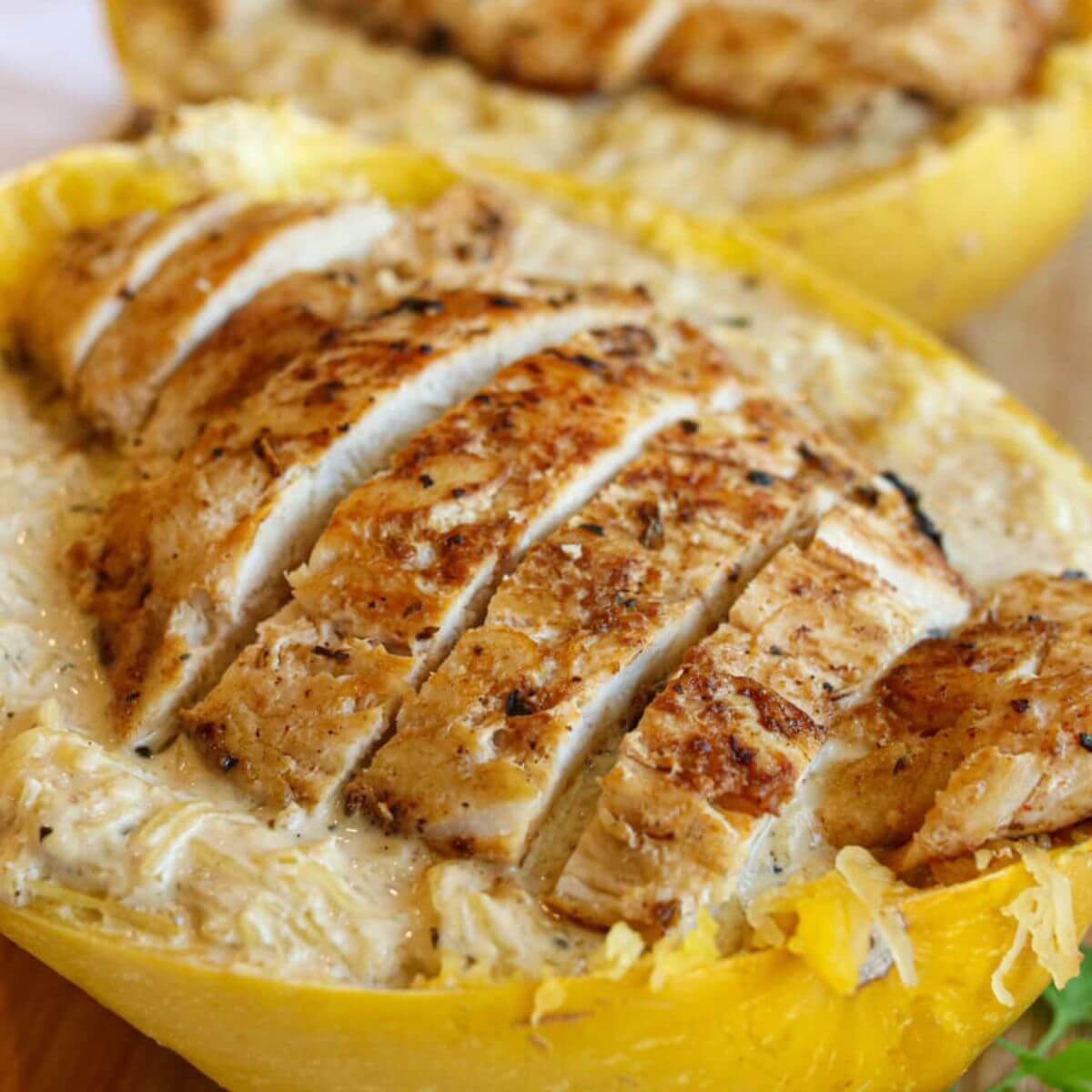 Closeup view of chicken Alfredo spaghetti squash served in a squash shell.