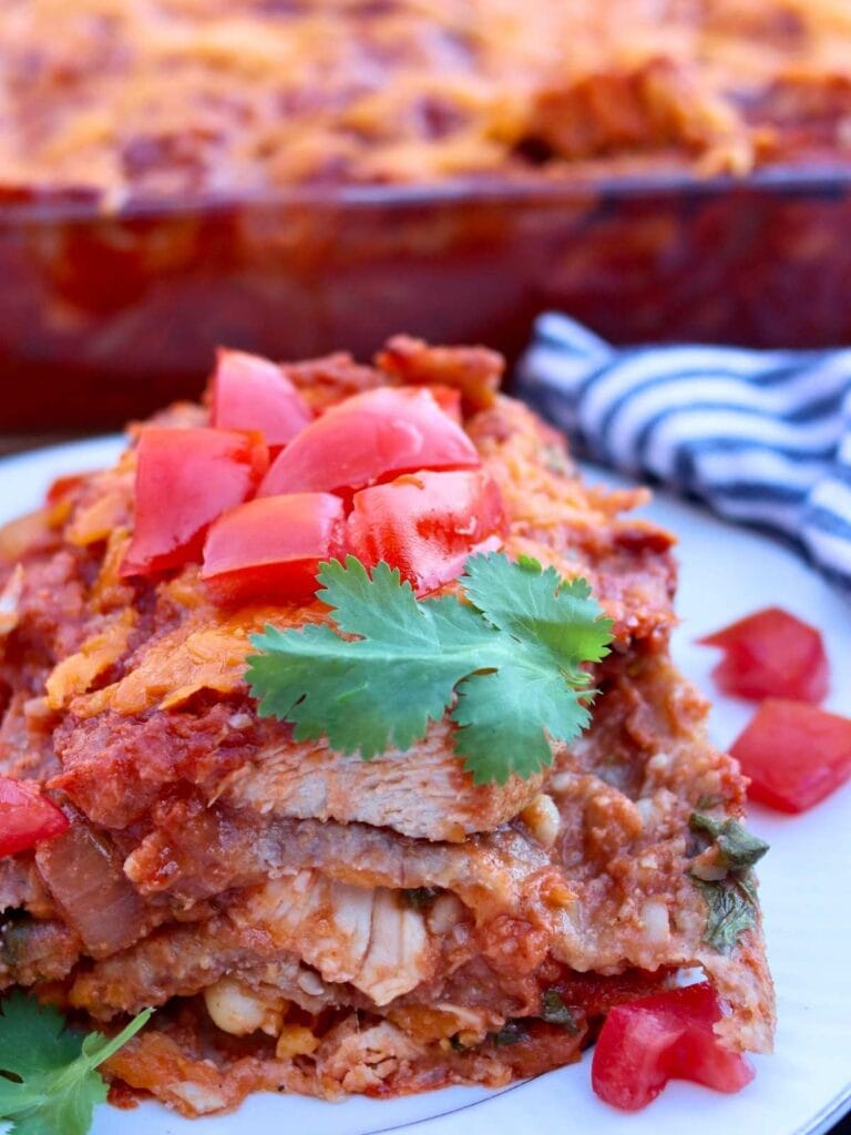 Slice of chicken enchilada casserole on a plate.