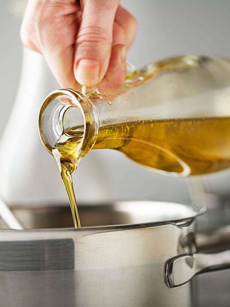 Pouring oil into a pan.
