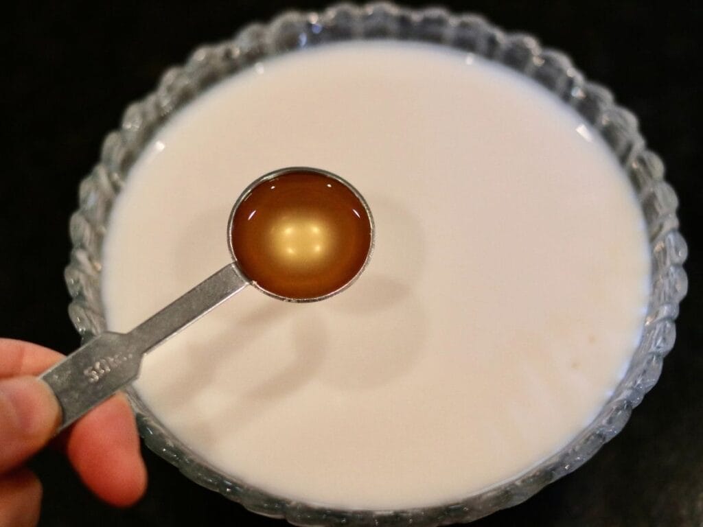 Adding apple cider vinegar to milk.