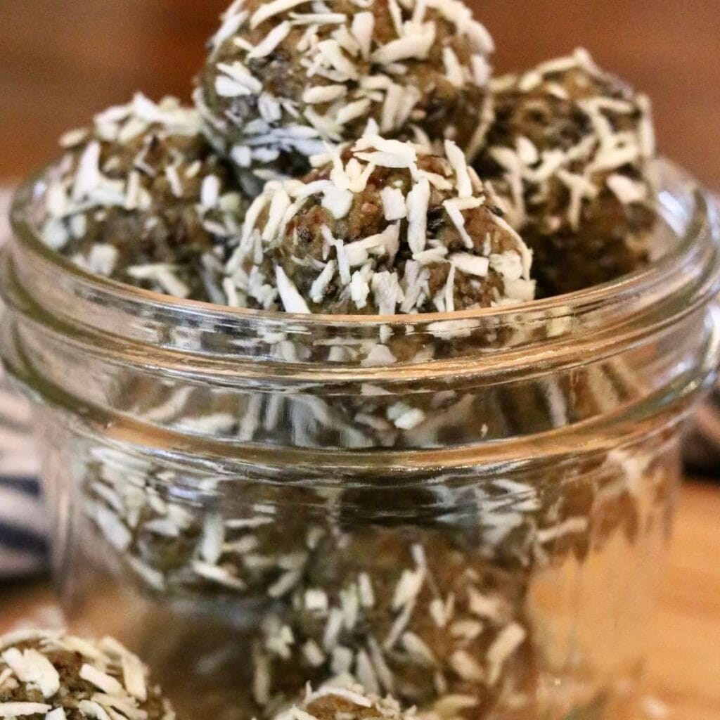 Oat-free protein balls with dates heaped in a glass jar.