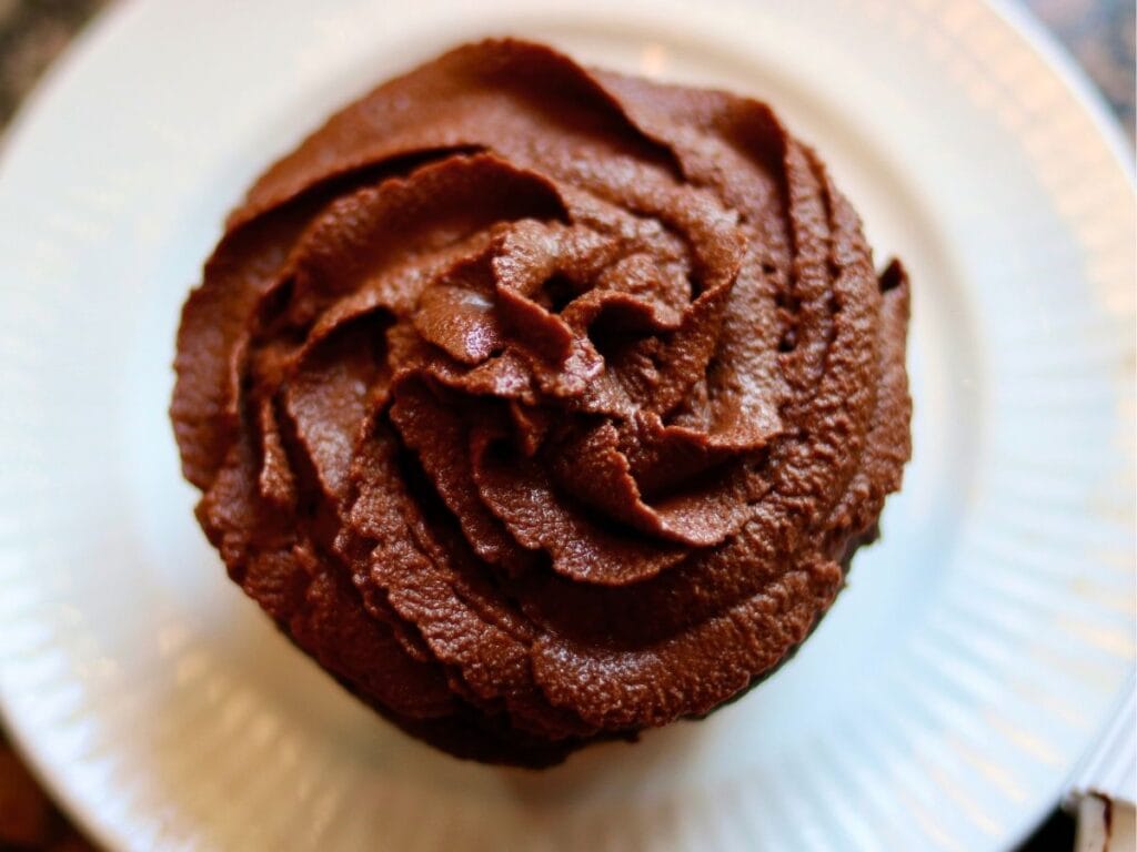 Top view of a cupcake with vegan chocolate frosting.
