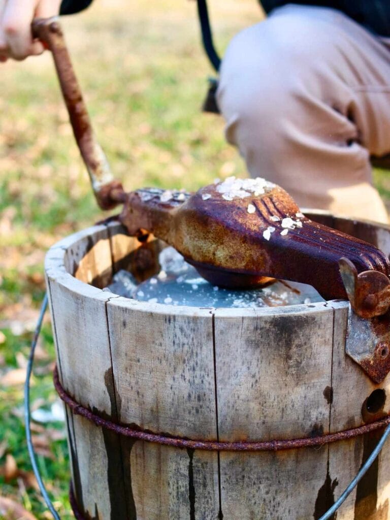 Man churning ice cream in an old-fashioned hand-crank ice cream maker.