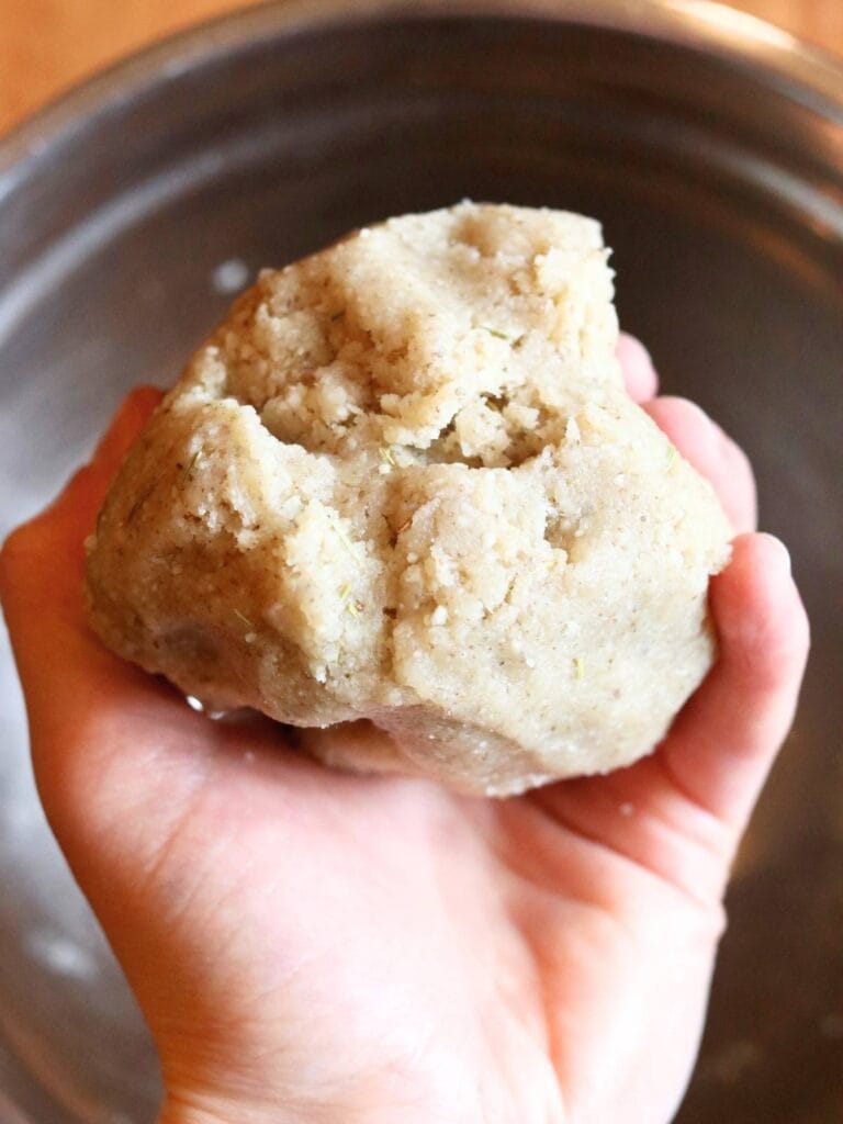 Hand holding dough for crackers.