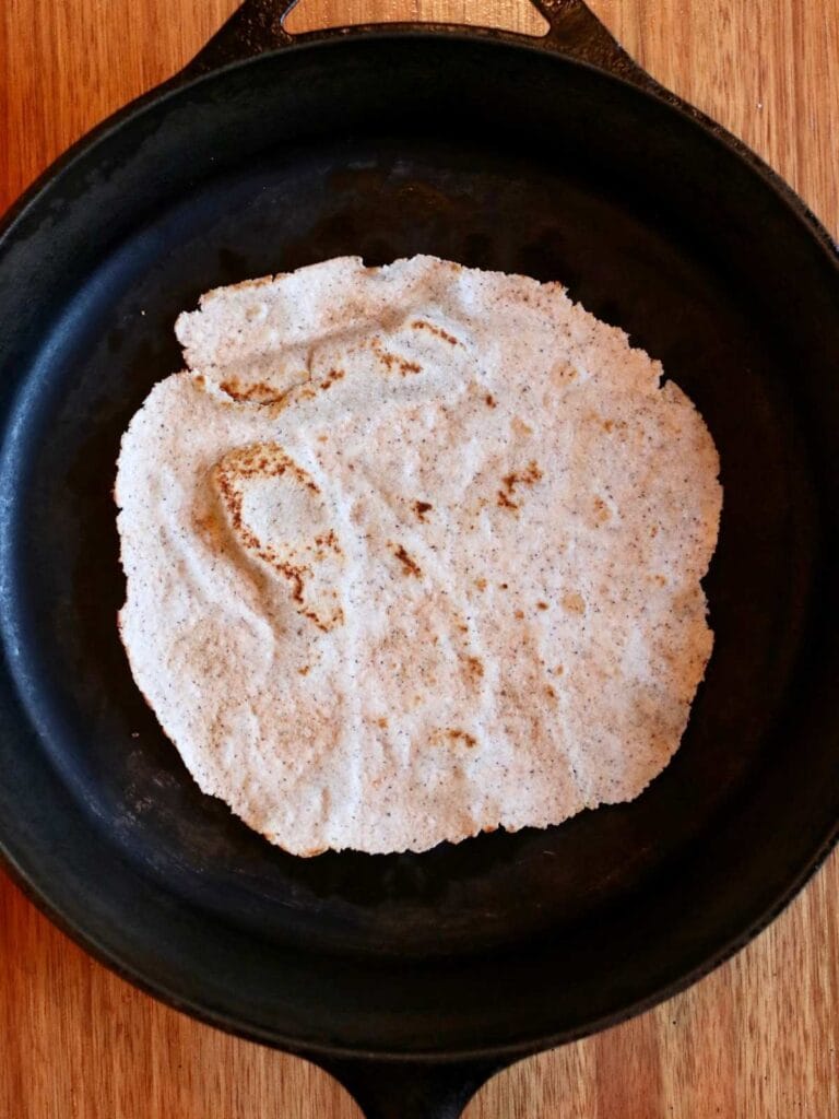 Tortilla cooking in a cast iron skillet.