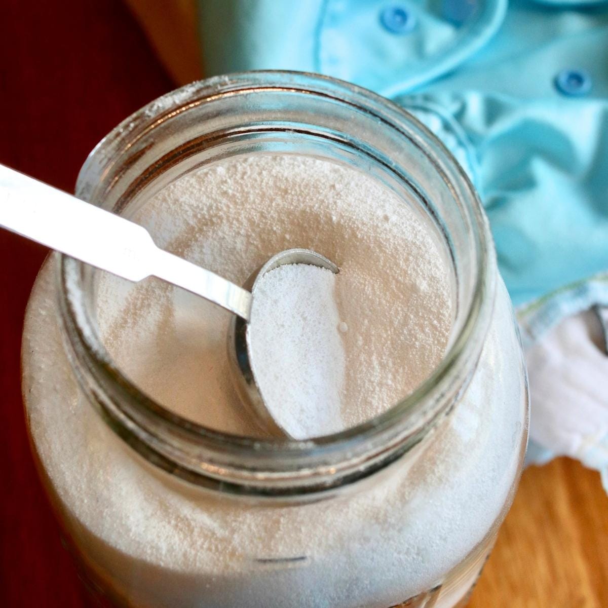 Closeup of spoon in a jar of cloth diaper detergent.