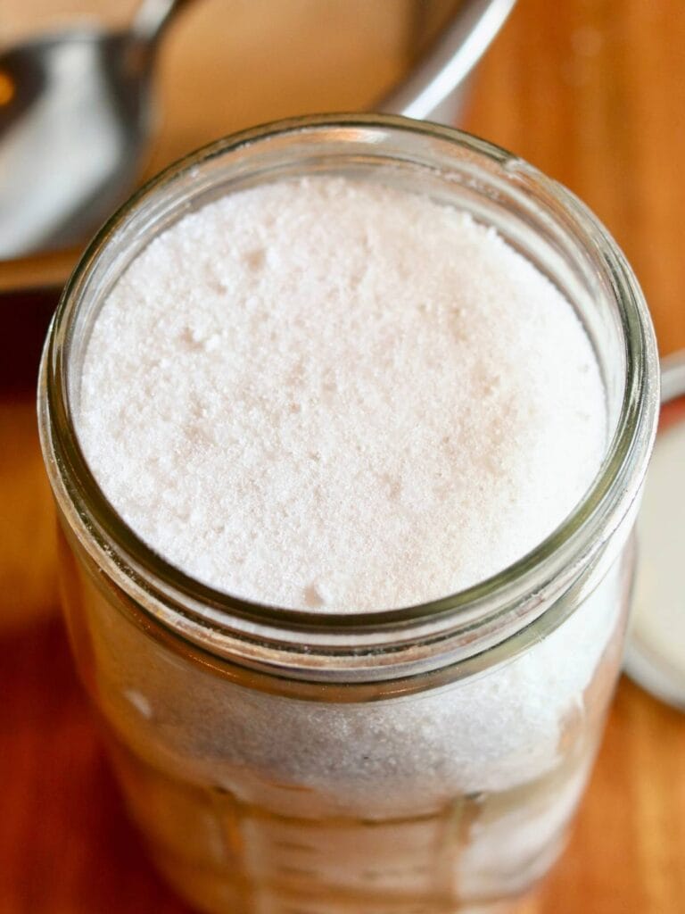 Homemade dishwasher detergent in a glass jar.