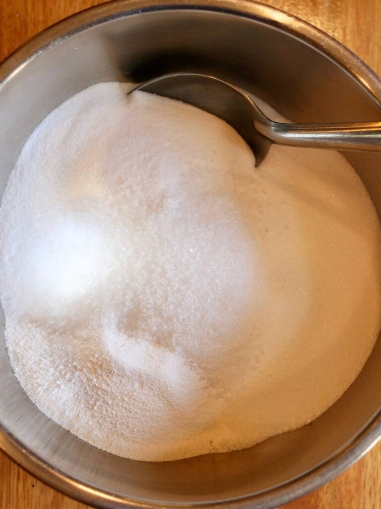 Stirring baking soda, washing soda, citric acid and salt in a bowl.