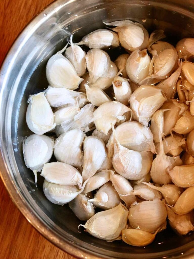 Garlic cloves soaking in a bowl of water.